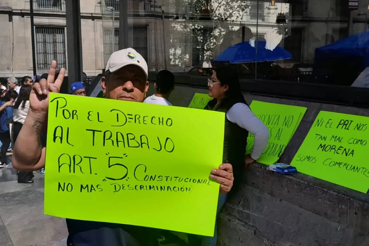 Comerciantes marchan con pancartas en Corregidora, Centro Histórico de la CDMX, para exigir derechos laborales y agua frente a la crisis por desalojos vinculados al Mundial 2026.