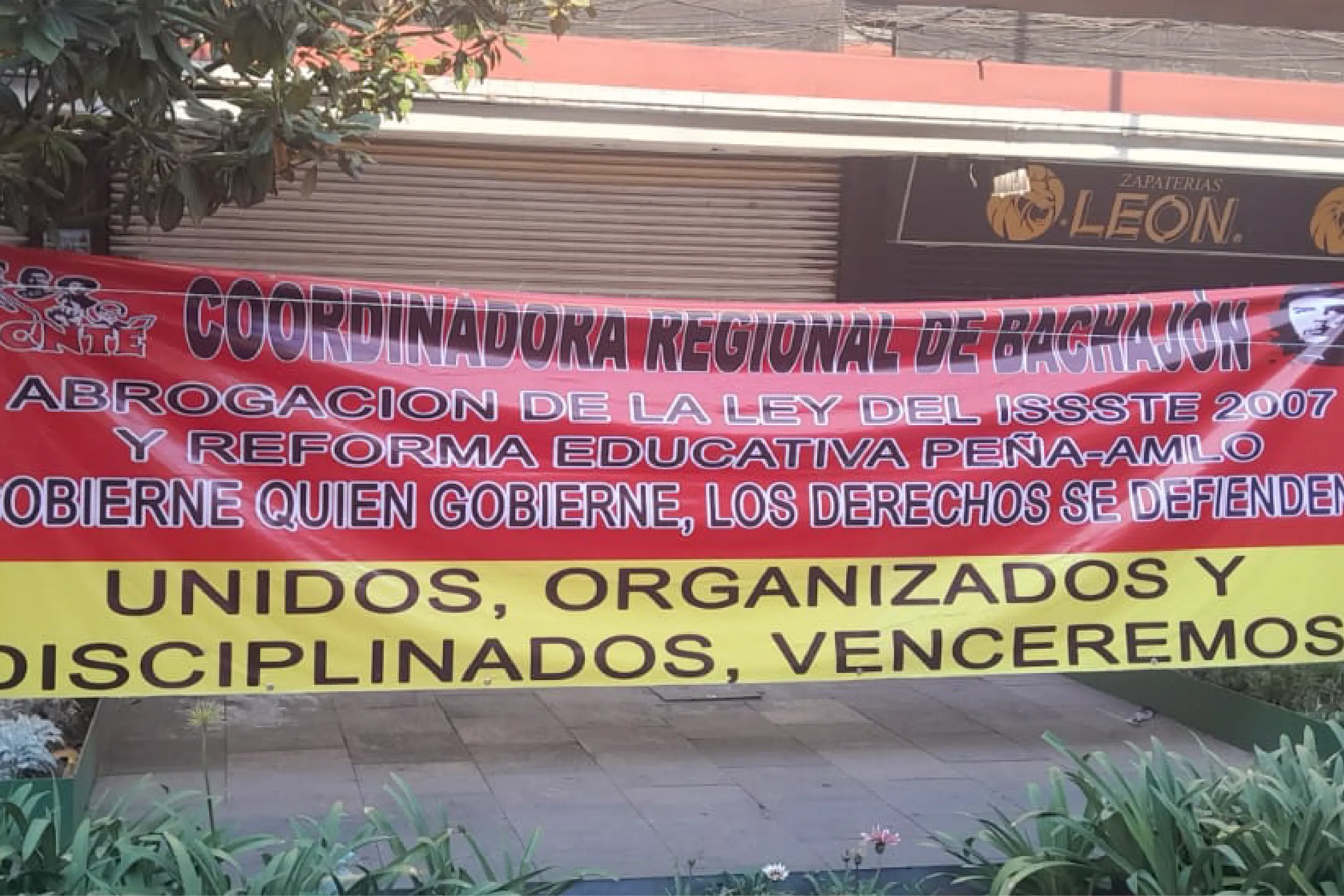 Red protest banner with bold text demanding the abrogation of the ISSSTE 2007 law, and a yellow strip reading 'UNIDOS, ORGANIZADOS'.